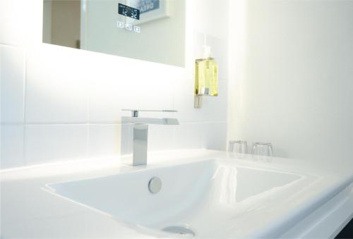 a white bathroom with a sink and a mirror at Gresham Court in Torquay