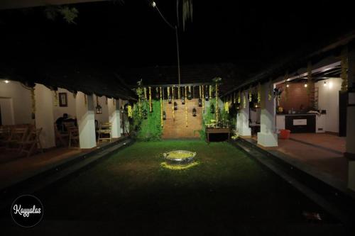 a night view of a room with a table and chairs at Kayyalas Courtyard in Trichūr