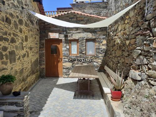 a stone building with a bench in front of a door at Casa do Pátio e Casa da Serra in Castanheira de Pêra