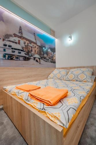 a bed in a room with a painting on the wall at Apartament Błękitny in Kazimierz Dolny