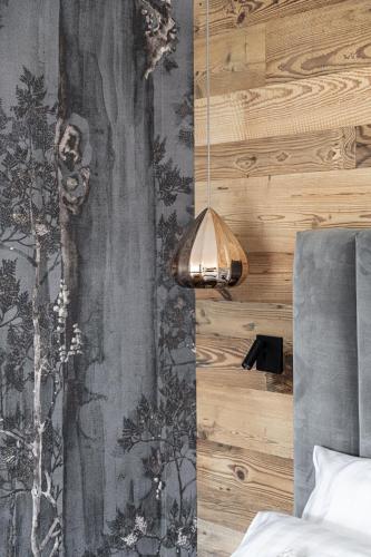 a bedroom with a wall with a wallpaper at Alpuris - Your Boutique Suite - Hotel B&B in Cavalese