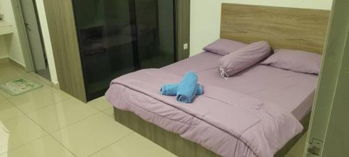 een bed met een blauw knuffeldier erop bij Idaman Homestay in Kampong Lumut Kiri