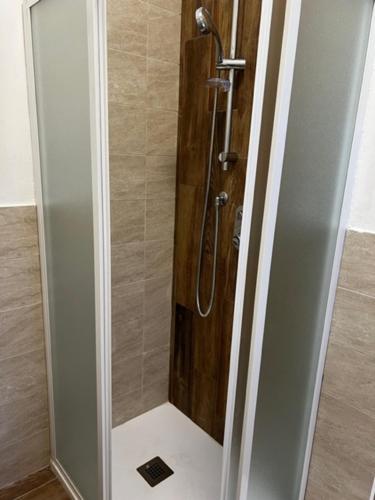 a shower with a glass door in a bathroom at We Love Tower Self Check-In in Pisa