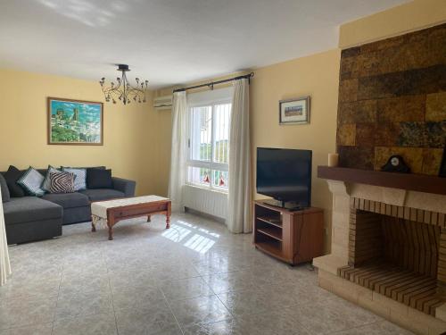 a living room with a couch and a fireplace at Agradable Adosado 3 plantas Altea in Altea