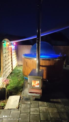 ブワディスワボボにあるUroczy domek z baliá z jacuzziの夜、裏庭のストーブと懐中電灯