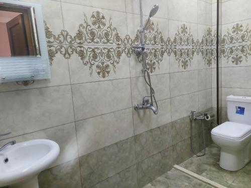 y baño con ducha, aseo y lavamanos. en SUNRISE Guest House, en İsmayıllı