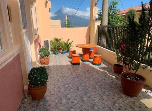 a patio with a table and some potted plants at Delightful House in the Heart of Legazpi, Albay. in Legazpi