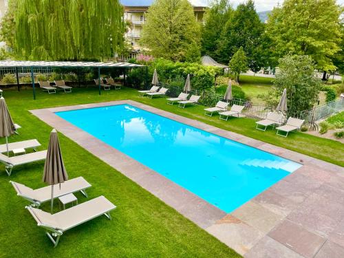 uma imagem de uma piscina com espreguiçadeiras e um resort em Hotel Turmwirt em Ora