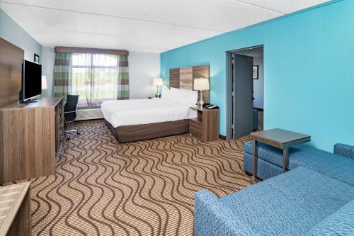 a hotel room with a bed and a flat screen tv at La Quinta by Wyndham Sevierville / Kodak in Sevierville