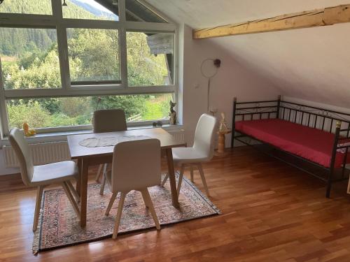 a dining room with a table and chairs and a bed at Ferienwohnung Dallinger in Radmer an der Stube