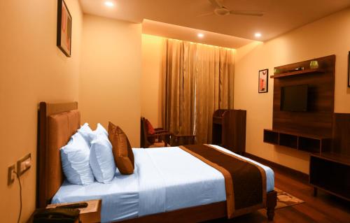 a hotel room with a bed and a television at The Abhyudyam Ganga in Haridwār