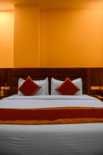 a bedroom with a large bed with red pillows at The Abhyudyam Ganga in Haridwār