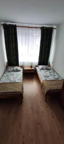a room with two beds and a window at Pokoje gościnne u Sławka in Ustka