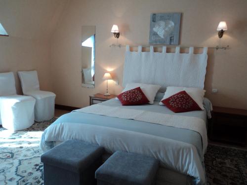ferme de séjour verchalles في Verchales-Soutro: غرفة نوم بسرير كبير ومخدات حمراء