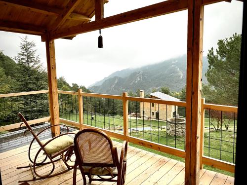 a porch with two chairs and a view of a mountain at La Torre d' Espinalbet in Castellar del Riu