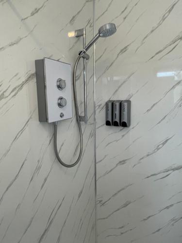 um chuveiro na casa de banho com paredes em mármore branco em Lovely 2 bed Apartment, Arnold Town centre. em Nottingham