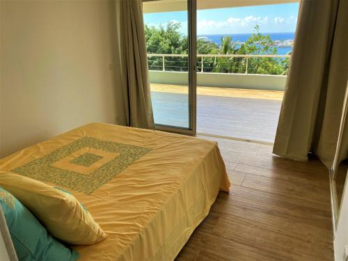 - une chambre avec un lit et un balcon dans l'établissement TAHITI - Raimiti Dream Apartment, à Fa'a'ā