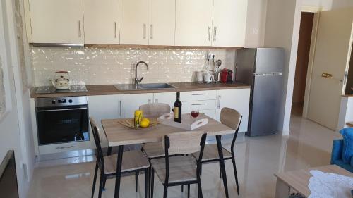 a kitchen with a table with a bottle of wine on it at Christos Katerina House in Pythagoreio