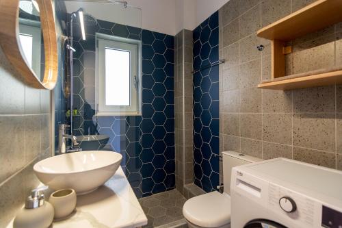 La salle de bains est pourvue d'un lavabo blanc et de toilettes. dans l'établissement Vakakis Family Luxury Studios 2, à Paleóchora