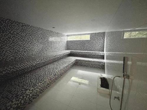 a bathroom with a shower with a tile wall at Club de Playa Samaria - T1 APTO 1705, Santamarta in Santa Marta