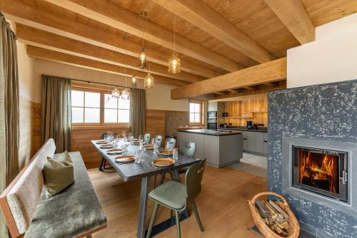 a dining room with a table and a fireplace at Almwelt Austria in Schladming