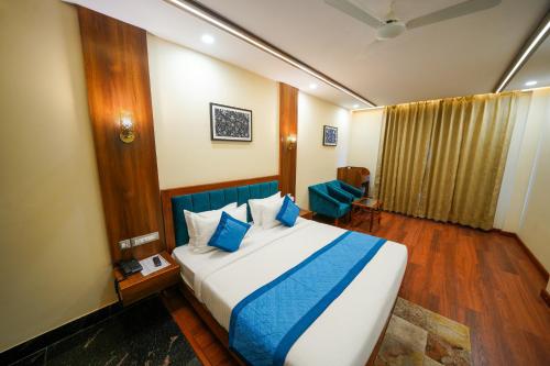 a bedroom with a large bed with blue pillows at The Abhyudyam Ganga in Haridwār
