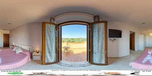 sypialnia z łóżkiem i dużym oknem w obiekcie Agriturismo IL VECCHIO OLIVO w mieście Castagneto Carducci