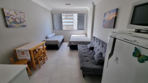 a small living room with a couch and a tv at Apartamento kit Praia Grande na Guilhermina Frente Mar in Praia Grande