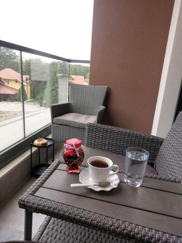 a cup of coffee on a table on a balcony at Happy Dreams Spa Zlatibor in Zlatibor