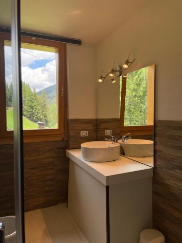 un bagno con due lavandini e un grande specchio di Residence Regina delle Alpi a Santa Caterina Valfurva