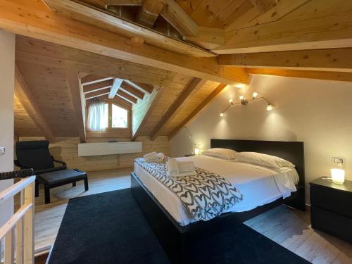 ein Schlafzimmer mit einem großen Bett in einem Zimmer mit Holzdecken in der Unterkunft Residence Regina delle Alpi in Santa Caterina Valfurva