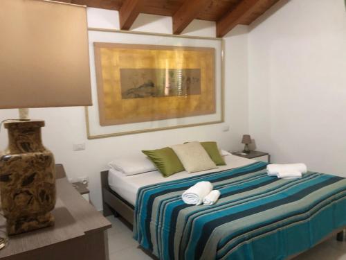 a bedroom with a bed with two towels on it at Cagliari Elmas Airport Beautiful Mansarda in Assemini