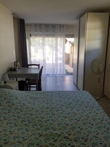 a bedroom with a bed and a dining room with a table at Les Lauriers in Espondeilhan