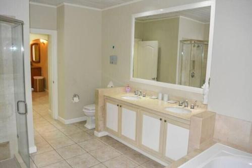 a bathroom with two sinks and a mirror and a toilet at The Bliss in Gros Islet