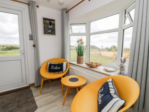 a living room with two chairs and a window at Porthwen Lodge in Amlwch