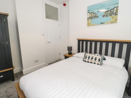 1 dormitorio con cama blanca y almohada en Amlwch, en Llandudno