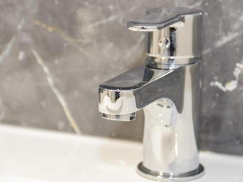 a silver faucet on a sink in a bathroom at Amlwch in Llandudno