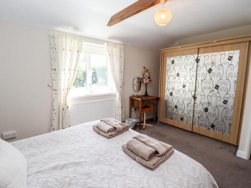 a bedroom with a large bed with two towels on it at Poppy Cottage in Sleaford