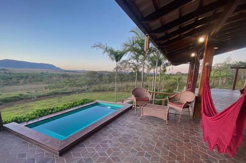 a patio with a hammock and a swimming pool at Sítio São Chico in Alto Paraíso de Goiás