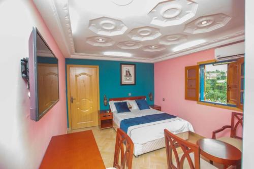 1 dormitorio con 1 cama y 1 dormitorio con mesa en Mont Bleu Hôtel, en Assougoula Emo