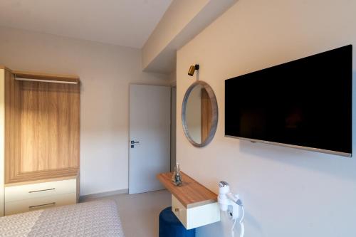 a bedroom with a flat screen tv on the wall at Vakakis Family Luxury Studios 2 in Palaiochóra
