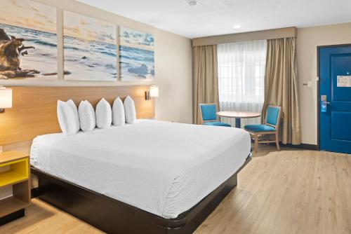 エルカホンにあるDays Inn by Wyndham San Diego-East/El Cajonのベッドとテーブルが備わるホテルルームです。