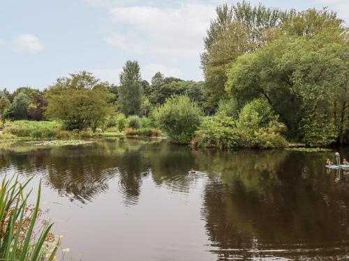 a river with people in a boat in the water at Bowland Lakes Leisure Village Lodge 16 in Preston