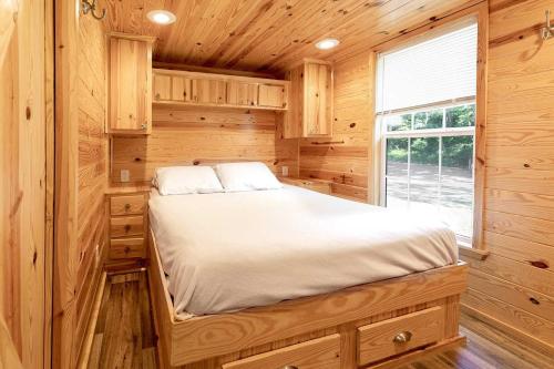 a bedroom with a bed in a wooden cabin at Halesford Harbour Resort - Smith Mountain Lake in Moneta