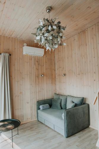 a living room with a couch and a chandelier at Silazari Klapkalnciems in Klapkalnciems