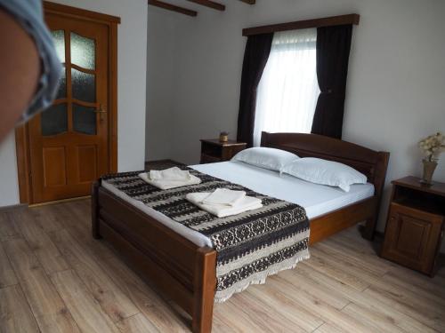 a bedroom with a bed with two towels on it at Wild-Traditional Bucovina in Câmpulung Moldovenesc