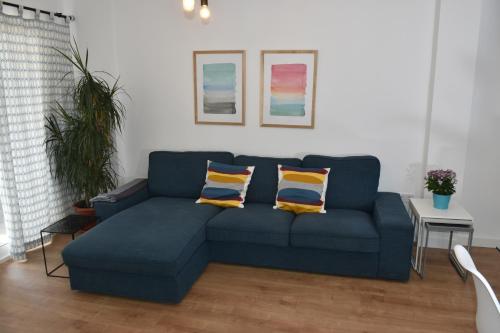 - un canapé bleu dans le salon avec deux oreillers dans l'établissement Spectacular Apartment 8 pax/4 rooms & Free Parking, à Malaga