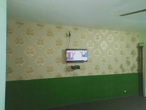 a room with a flat screen tv on a wall at Kanikasundari Home Stay in Bālianta