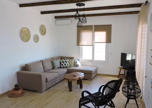 a living room with a couch and a table and chairs at Onar Luxury Villa - Adults Only in Lachania