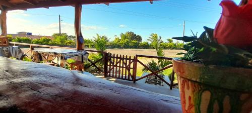 a porch with a table and a fence and a plant at Pousada Vale Encantado in Serra de São Bento